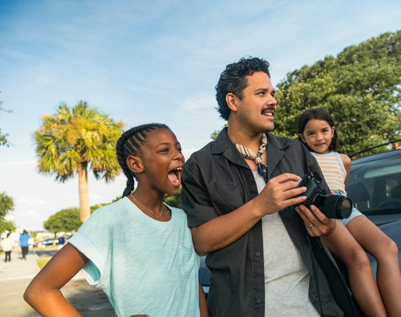 Man with two girls looking away