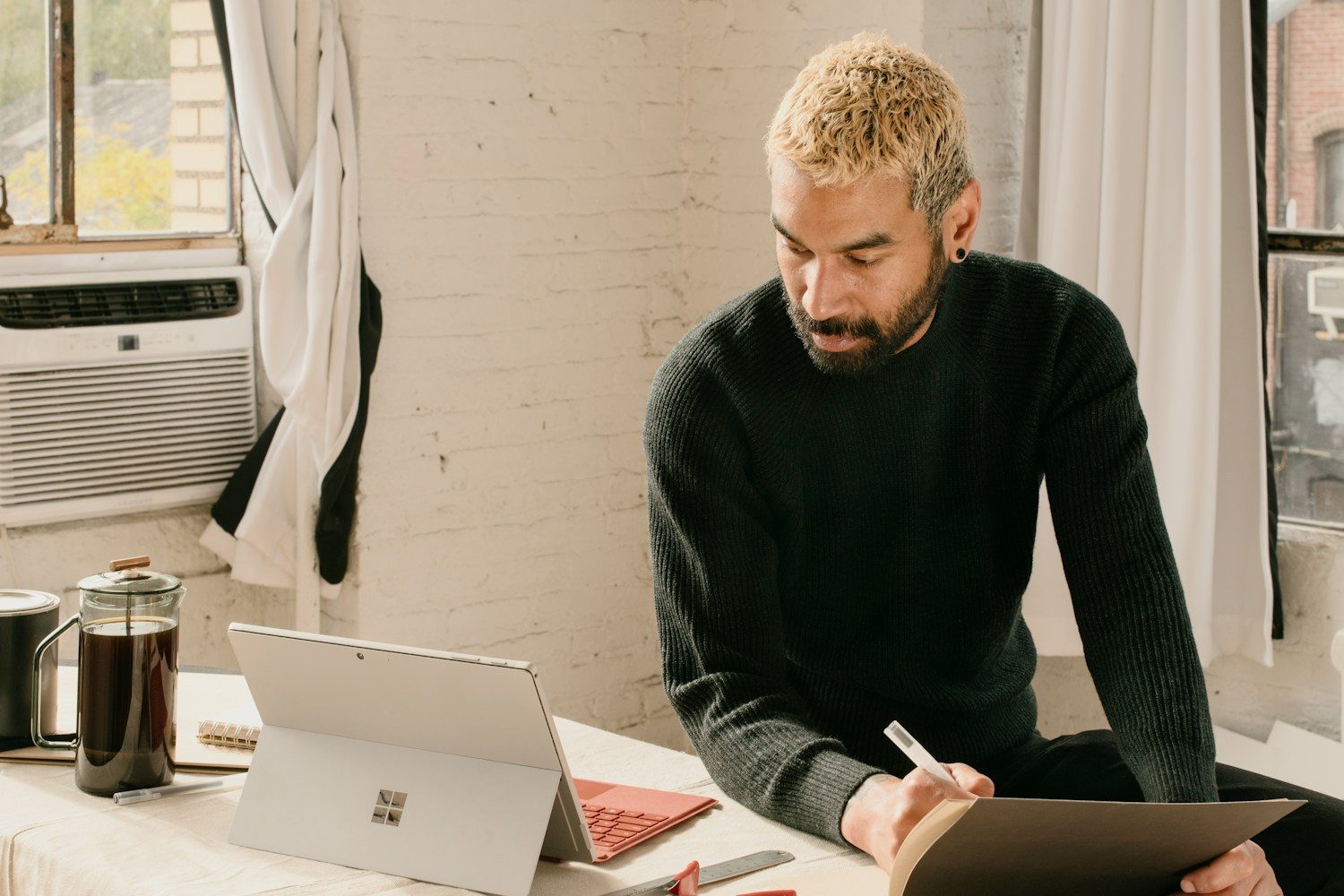 a man sitting at a table with a laptop and notebook